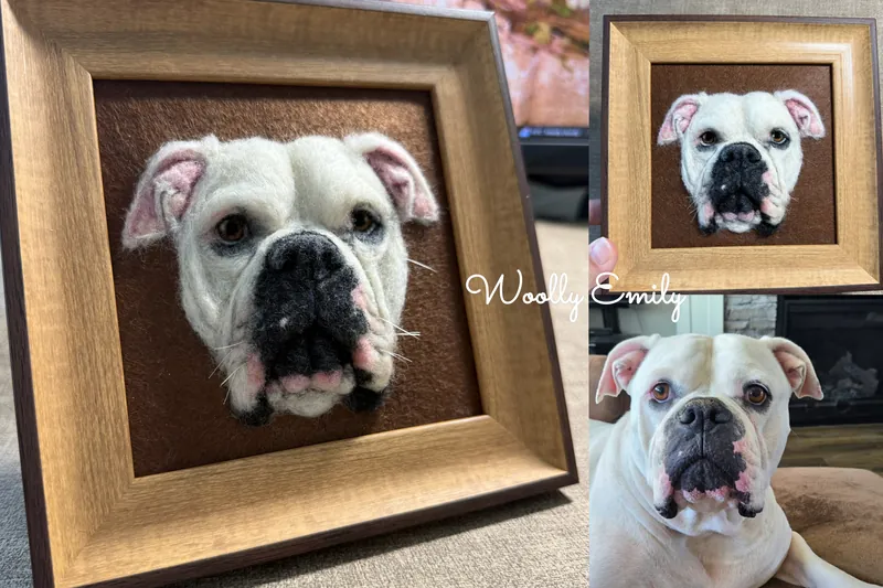 Needle felted white bulldog portrait in a light wood frame shown beside the real dog