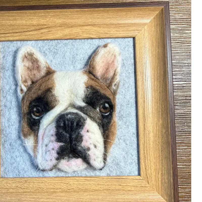 Framed needle felted bulldog portrait beside the reference photo