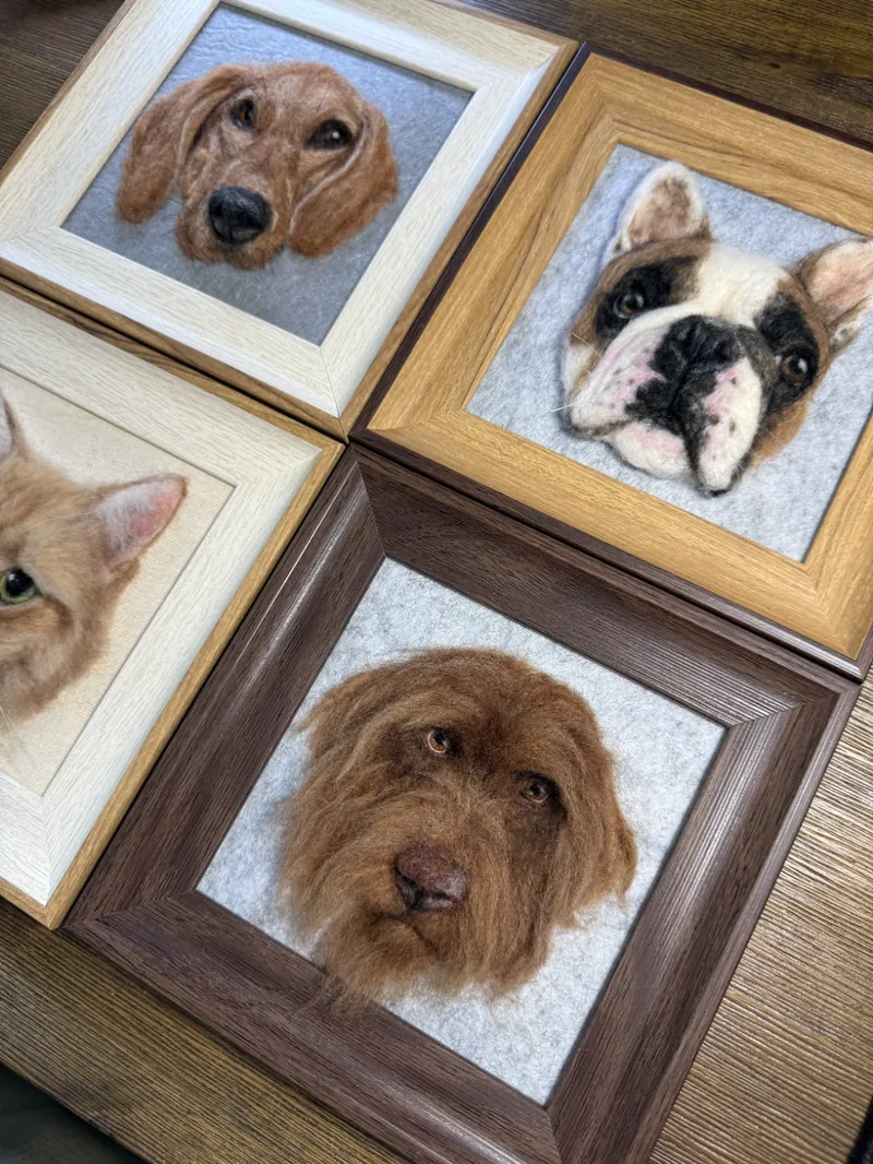 Framed needle felted portrait of a wirehaired dog beside its reference photo